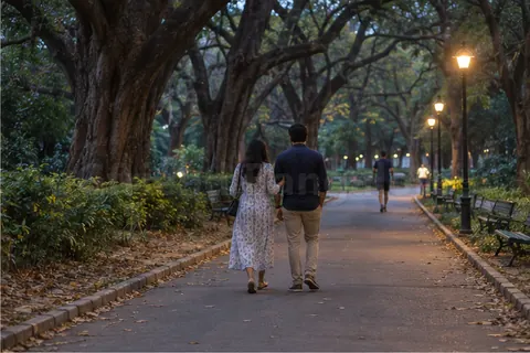 A couple walking away under big old trees in Cubbon Park at dusk